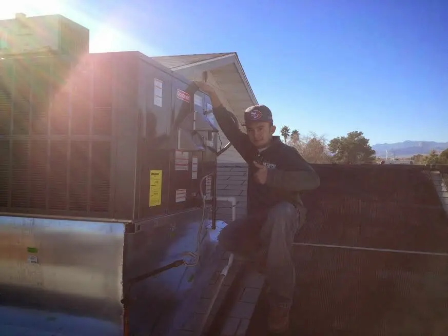 HVAC technician performing Heat Pump Repair on a rooftop unit in Hanover